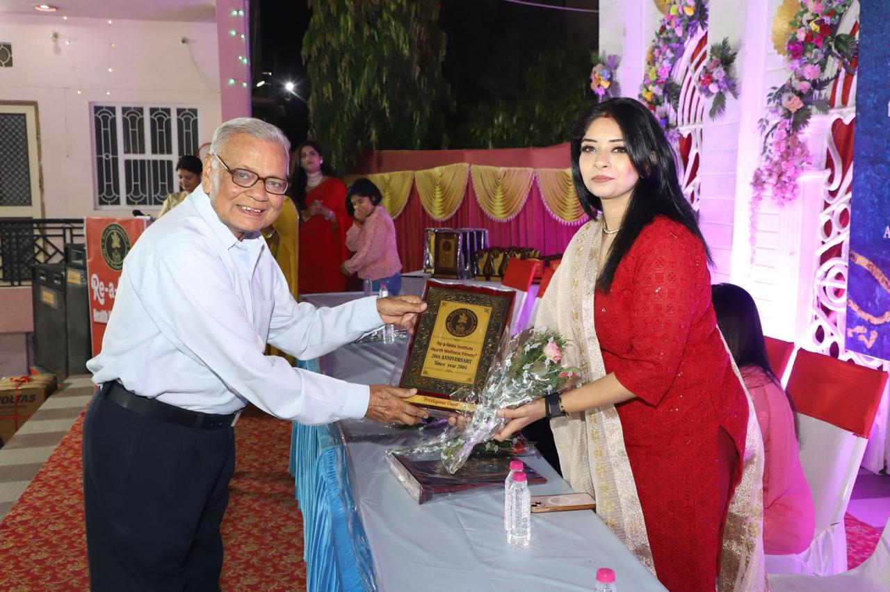 Pallavi Raghuwanshi receiving an award plaque and flowers